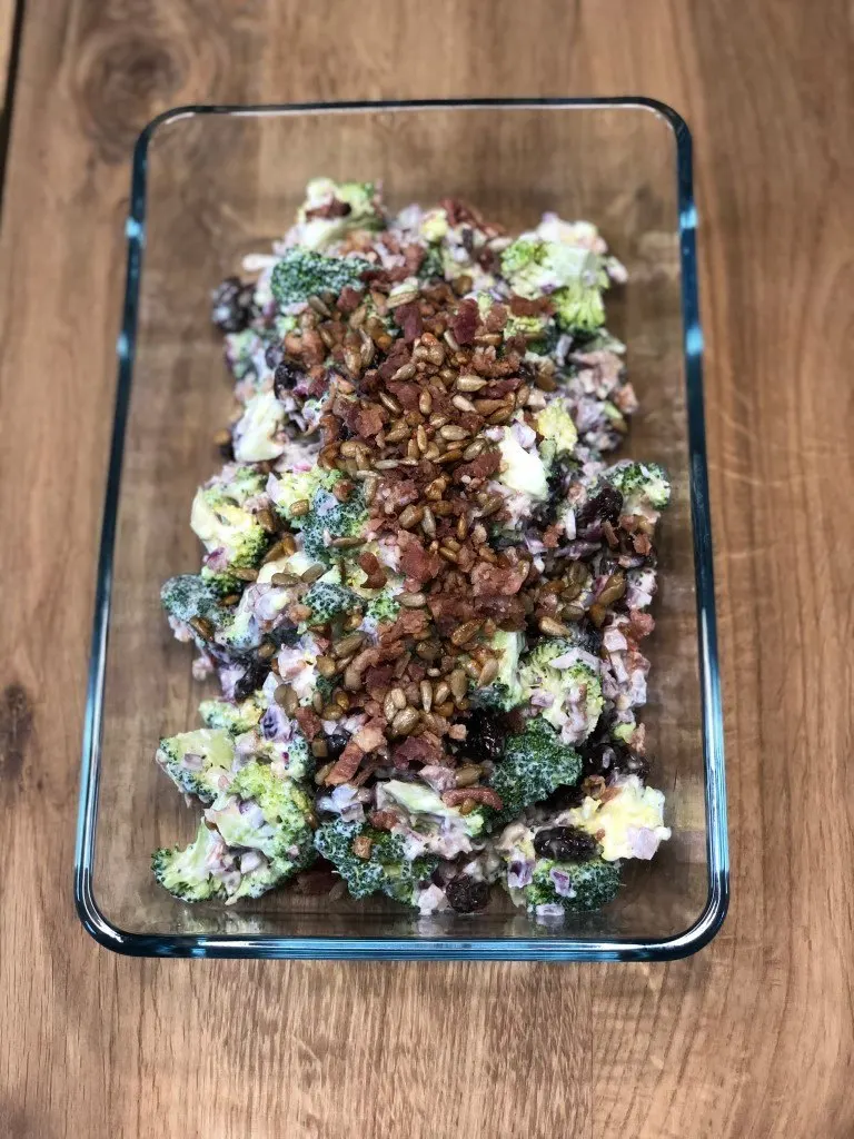 Broccolisalat med bacon og solsikkekerner i et glasfad